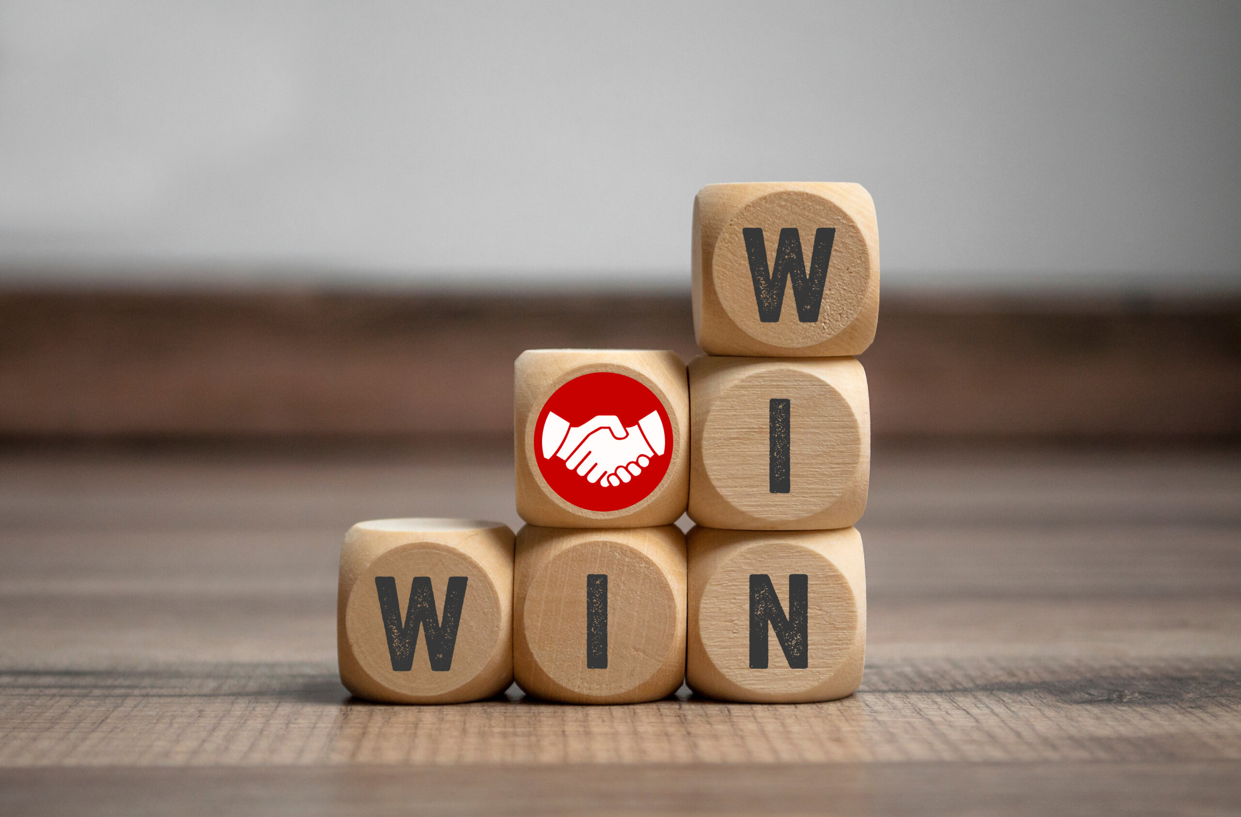 negotiation Cubes and dice with handshake icon and win-win-situation on wood